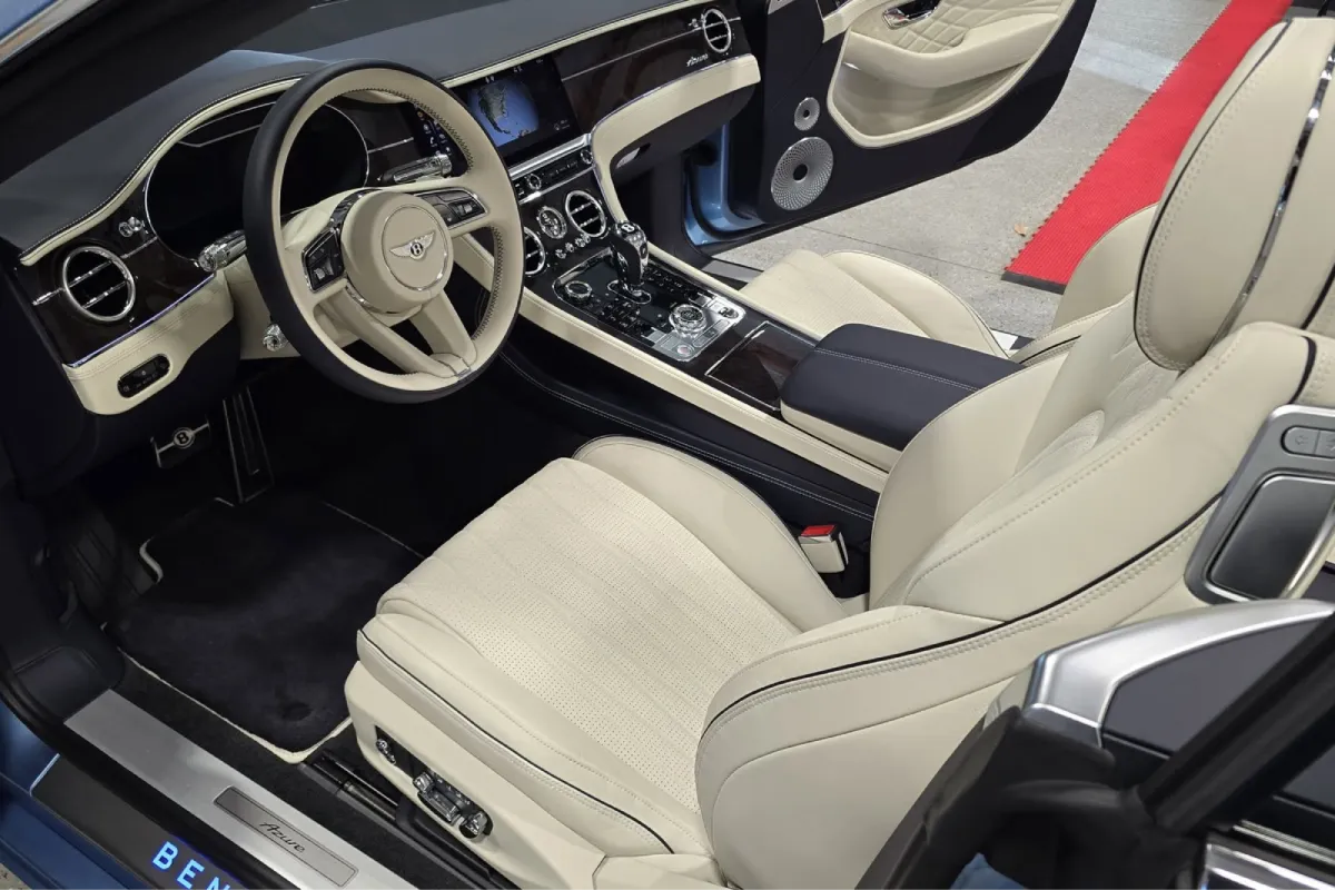 Bentley convertible interior with beige leather seats and dashboard.