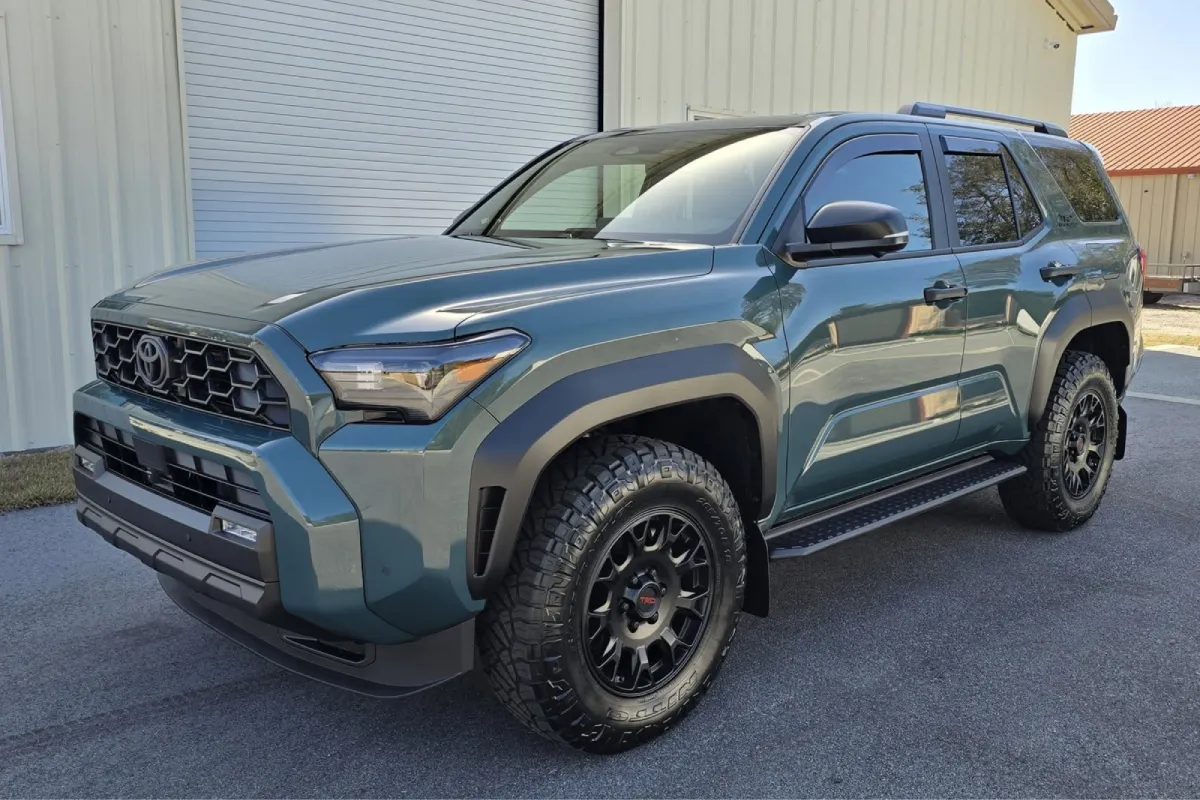 Green Toyota parked with a close-up of the front grill and black wheels.