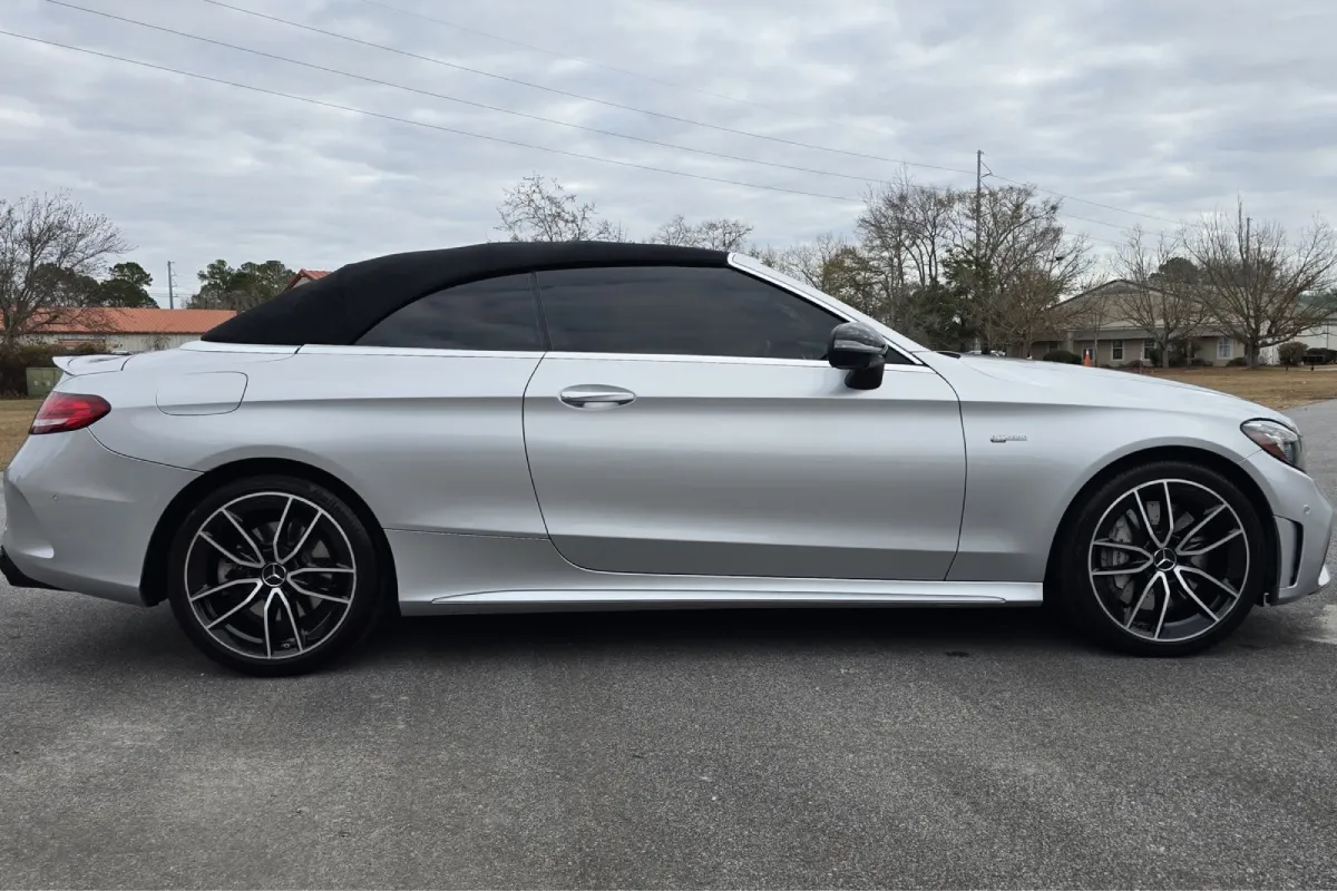 Silver Mercedes-Benz convertible with black soft top parked outdoors