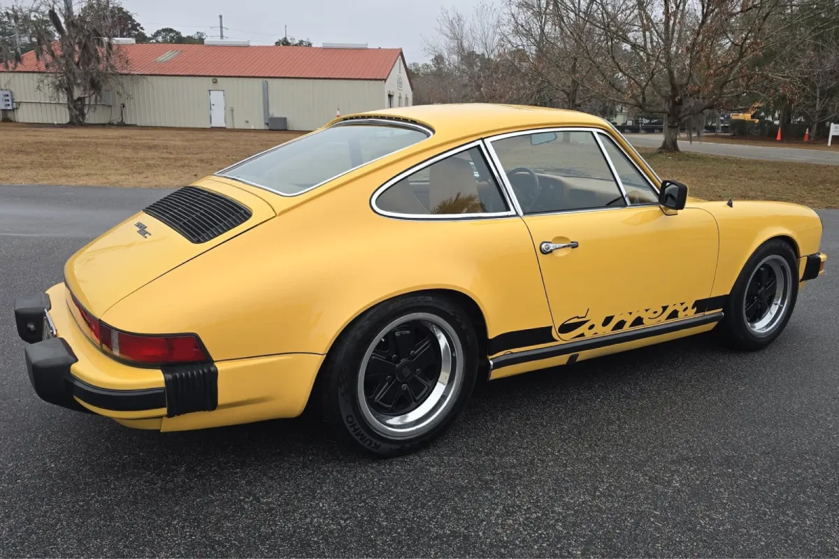 Yellow Porsche with classic styling, parked outdoors