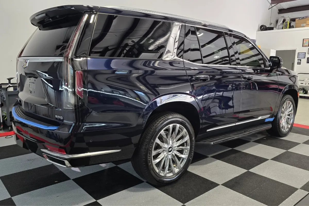 Cadillac Escalade with glossy paint correction finish in detailing shop.