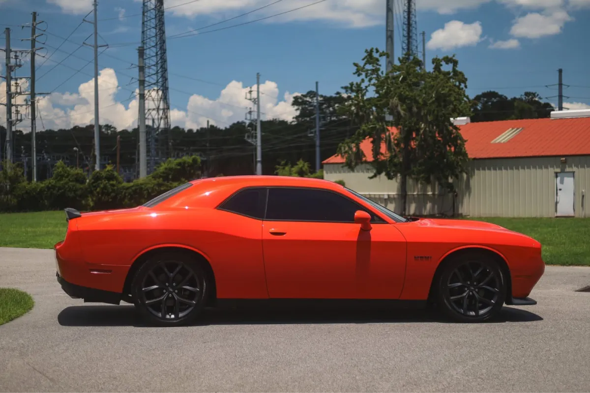 Red Dodge Challenger showcasing smooth paint after paint correction.