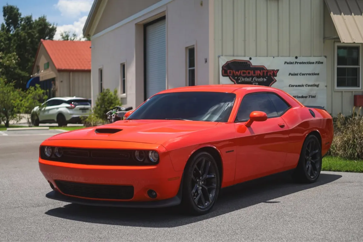 Red Dodge Challenger with a glossy finish after paint correction.