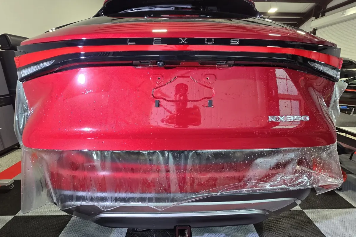 Paint protection film being installed on a Lexus rear bumper.